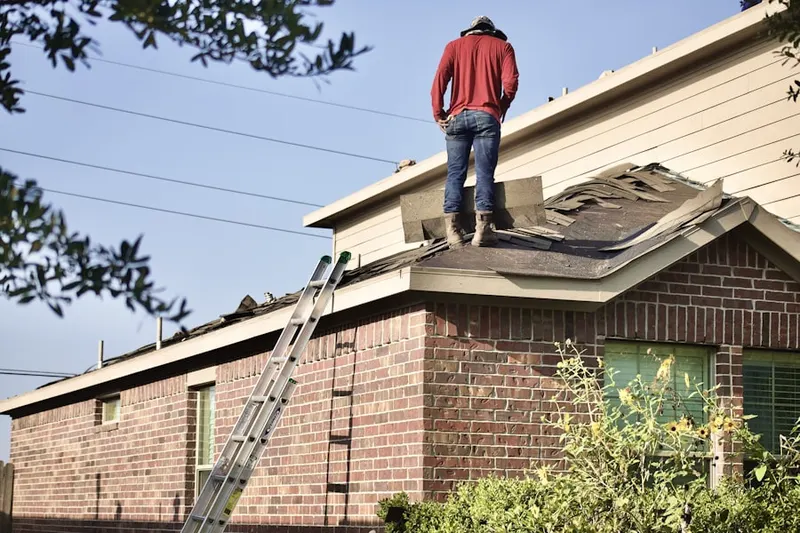 Professional roofer working on a residential roof in Wolcott Road